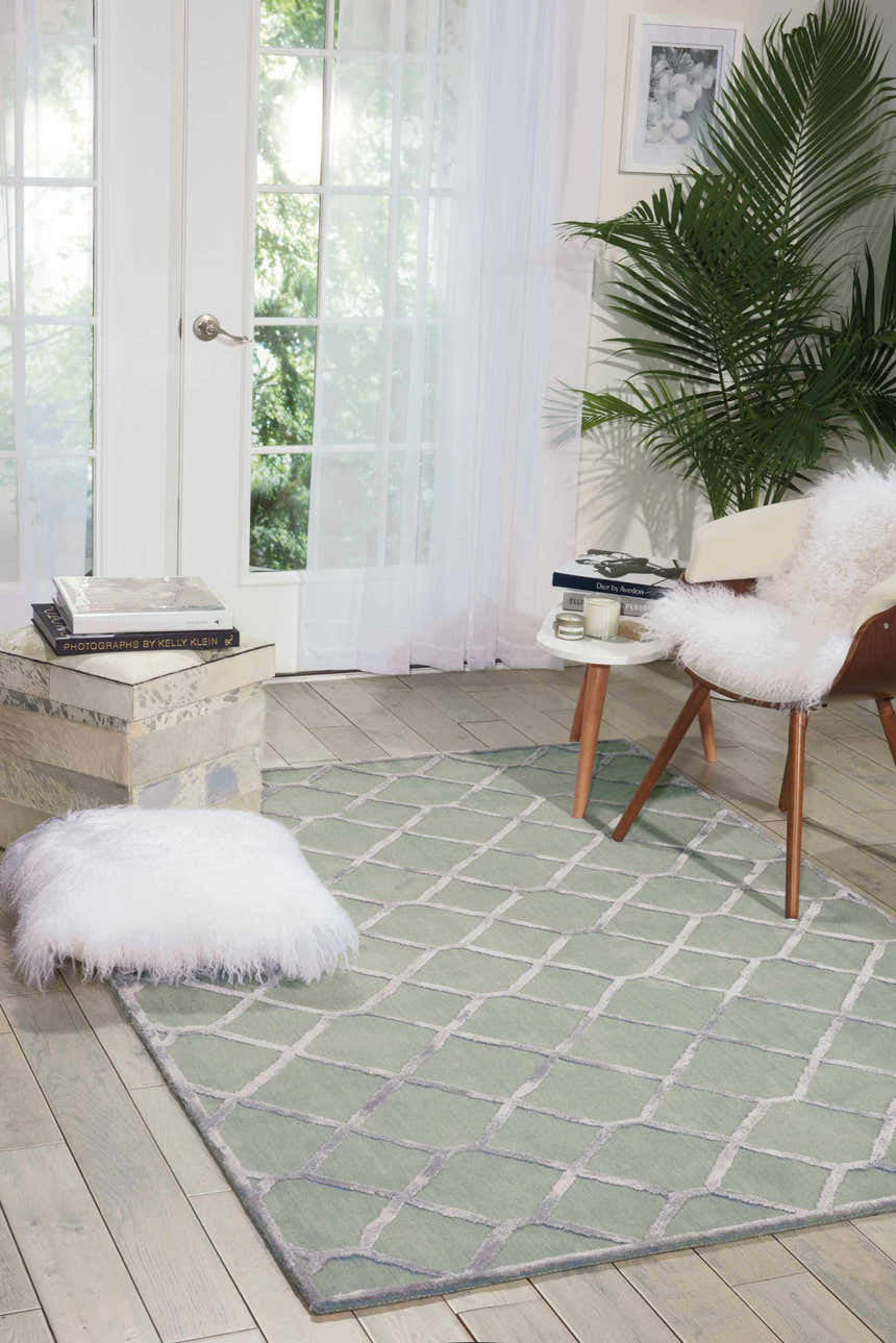 Sunlit room with Nourison Vita Sage rug, geometric pattern, muted sage and charcoal colors, modern chair, and white accents.