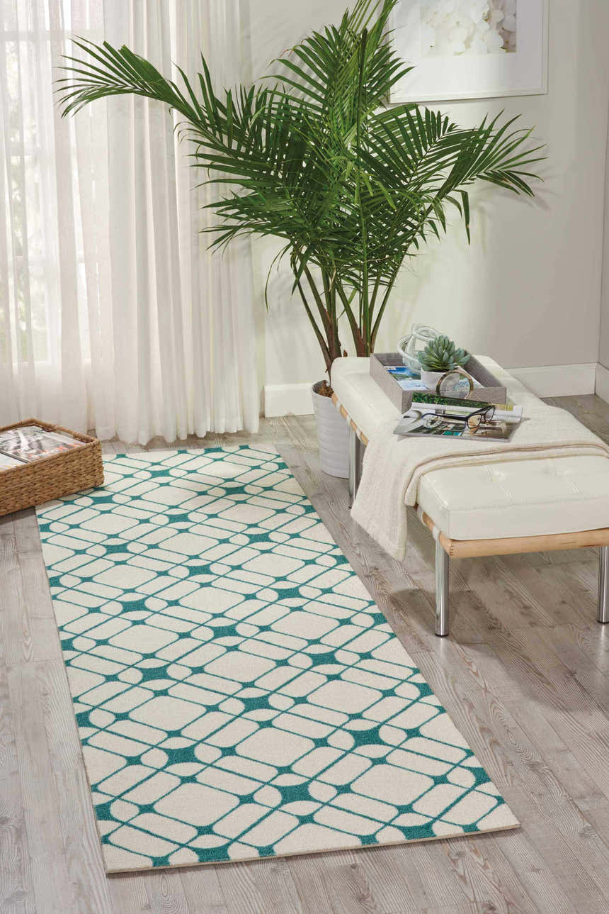 Bright sunroom with Nourison Enhance Ivory/Turquoise runner rug, white bench, and potted palm.