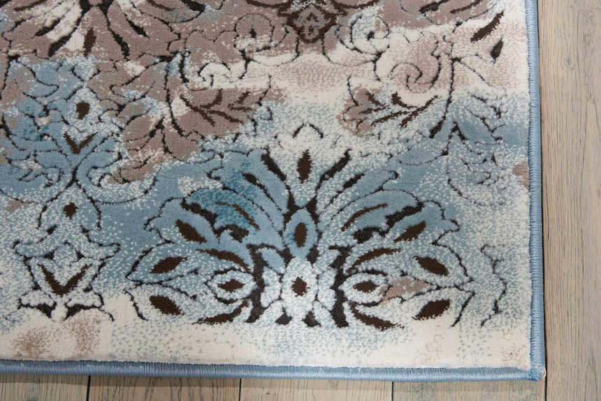 Close-up of the Nourison Karma Ivory/Blue rug. Vintage style rug with chestnut, ivory and blue floral pattern.