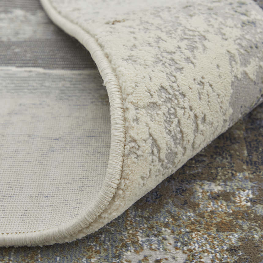 Close-up of Feizy Clio rug showing the brown, gray, and black watercolor design and textured pile. Fold