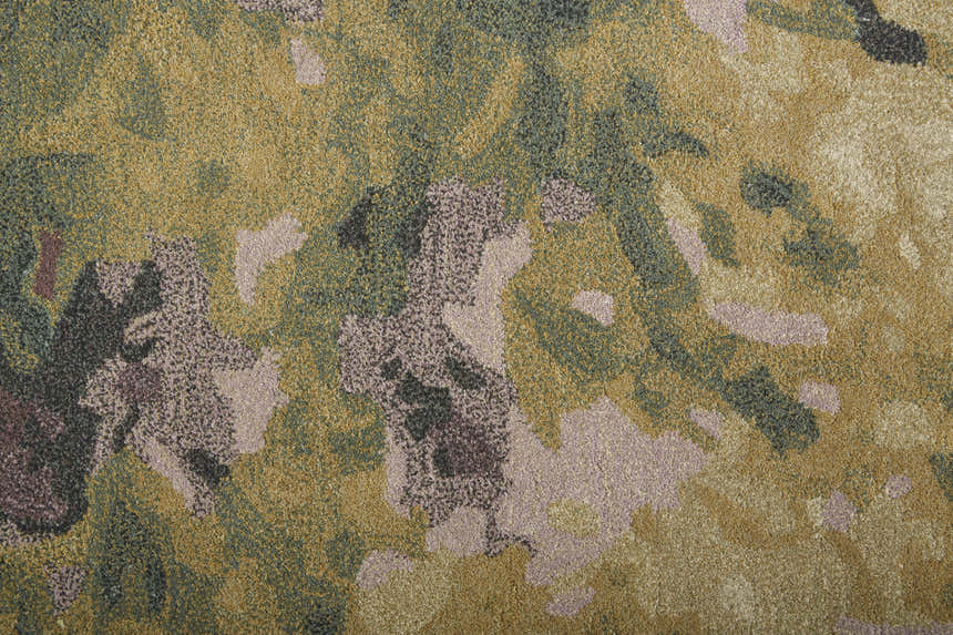 Close-up of the Feizy Amira rug, showing its gold, green, and purple abstract pattern and hand-tufted wool texture. Texture