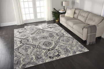 Living room with a neutral sofa and Nourison Twilight Ivory Grey Vintage rug on dark wood floors.