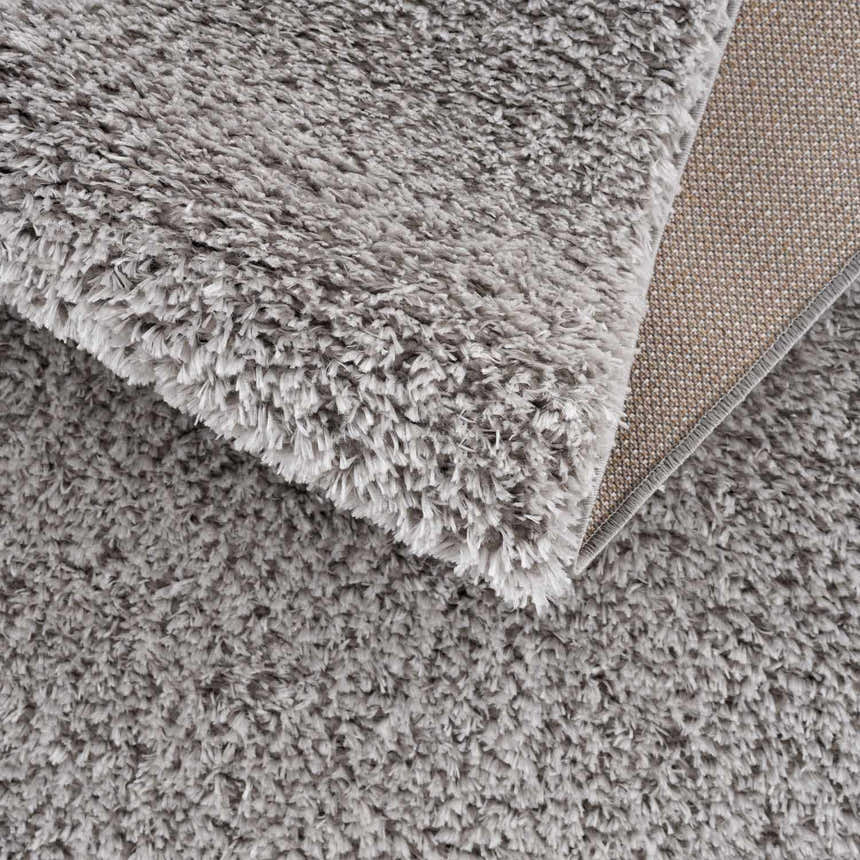 Close up of the plush texture and backing of the Lunaro Gray shag rug. Fold