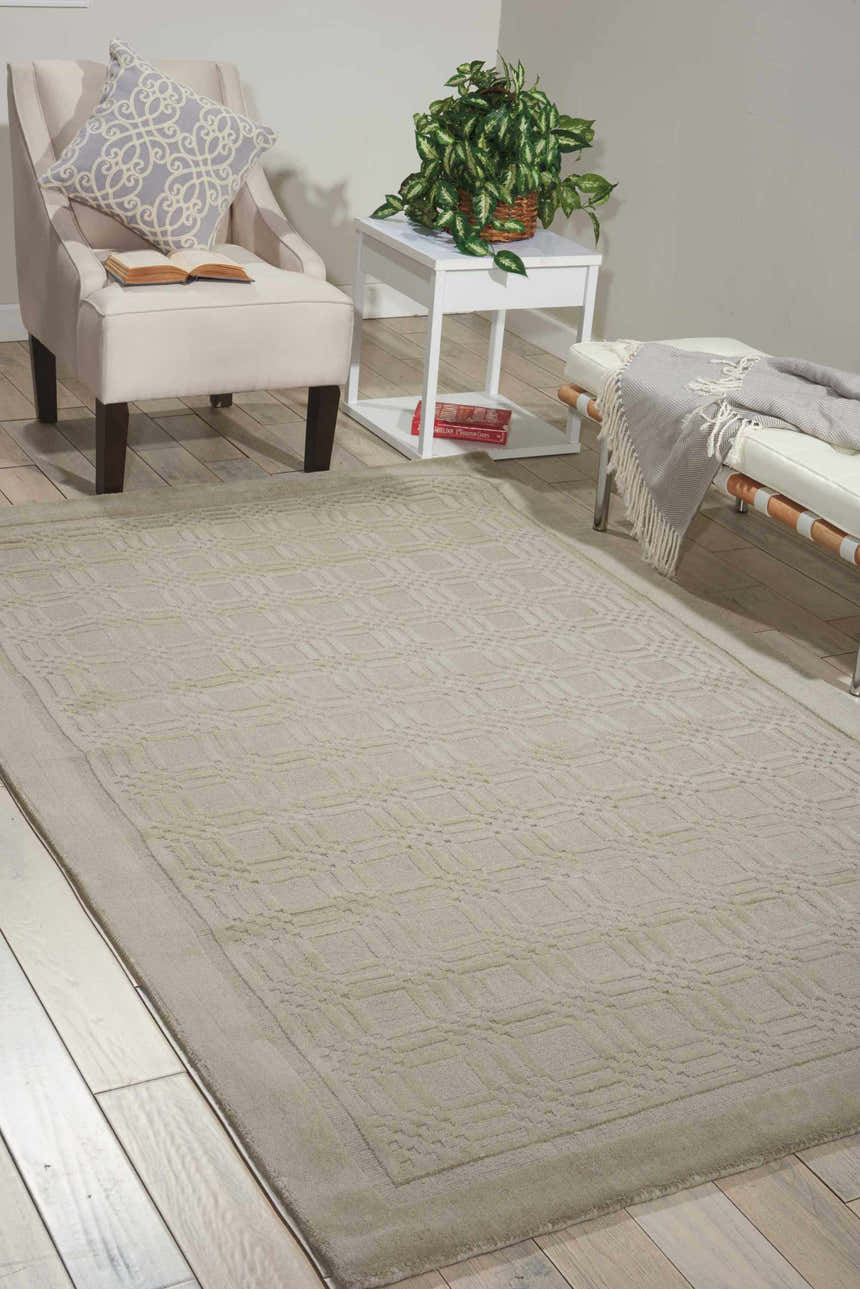 Living room scene with a Nourison Westport Grey rug, armchair, white table, and bench.