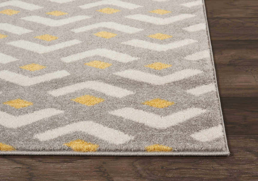 Close-up of Nourison Harper Grey Colorful rug showing geometric pattern in gray, white, and yellow on a wood floor.