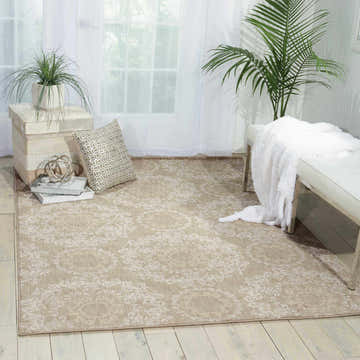 Light-filled room with sandstone Nourison Tranquility rug, white bench, and plants for a serene, bohemian vibe.