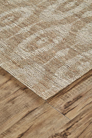 Close-up of the hand woven Feizy Lilliana rug. Tan and ivory jute rug with a geometric pattern. Corner