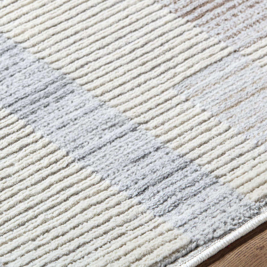 Close up of the Chouko Broken-Striped Area Rug showing beige, brown, and silver gray stripes. Contemporary style. Texture