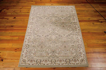 Close-up of Nourison Walden Light Green Persian rug showing floral pattern and border on wood floor. Clearance item.