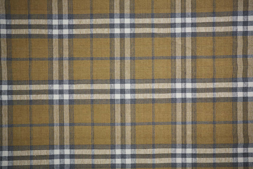 Close-up of Feizy Crosby Transitional Plaid Area Rug. Gold, blue, and white plaid pattern. Hand woven polyester rug. Texture