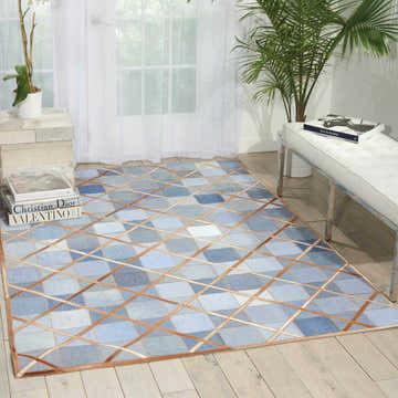 Bright room scene with a Barclay Butera Cooper Denim area rug featuring a geometric patchwork design in blue and tan.