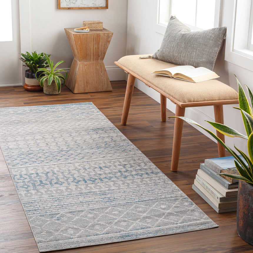 Hallway scene with Tambac Blue & Gray Washable Area Rug, wood bench, plants, and books creating a cozy, transitional style. Roomscene-Runner