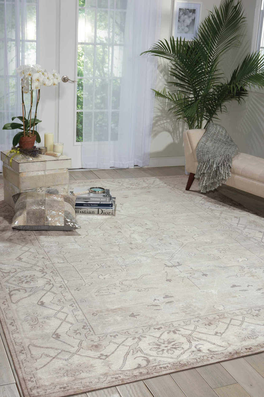 Bright living room with a Nourison Aldora Silver Vintage rug, daybed, and plants.