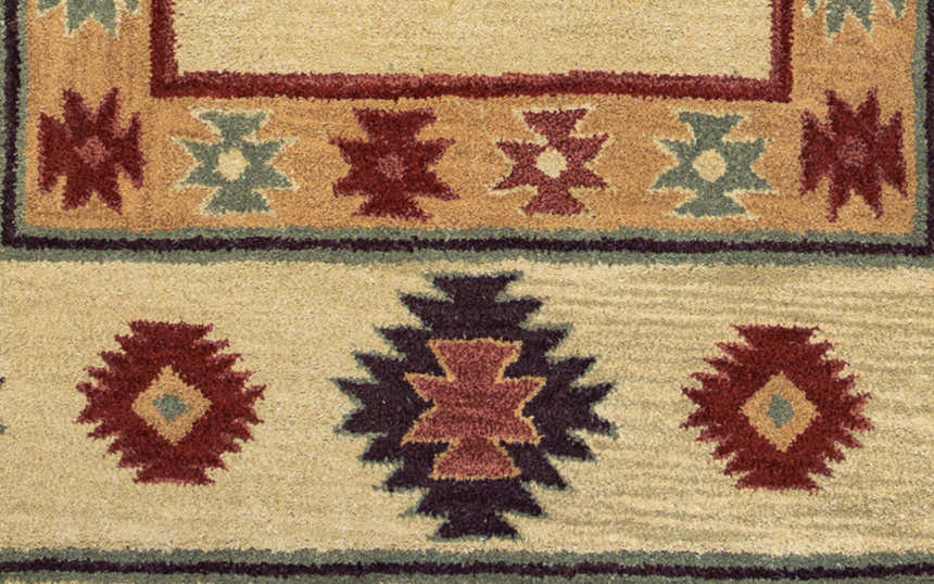 Close-up of Rizzy SU2015 area rug featuring beige, burgundy, navy, and sage Southwestern-style wool design. Texture
