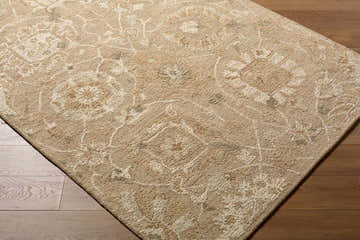 Close-up of the Lanune Traditional Handmade Area Rug showing its beige, ivory, and sandstone floral pattern and wool texture. Corner