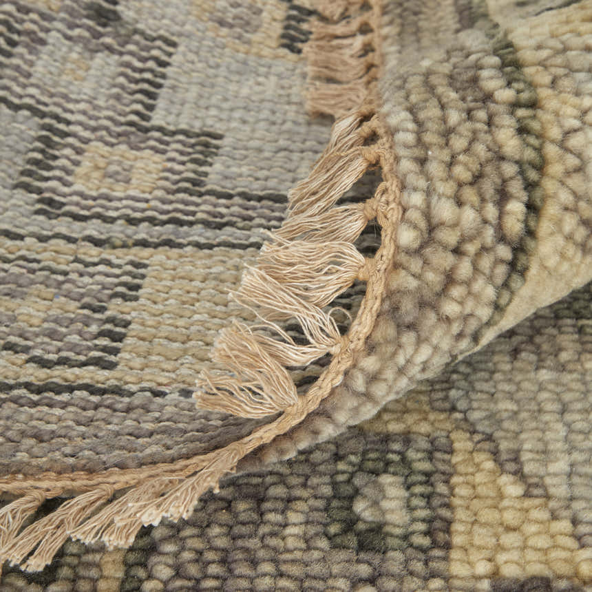Close-up of the Feizy Fillmore Traditional Diamond rug in brown and gray, showing wool texture and fringe detail. Fold