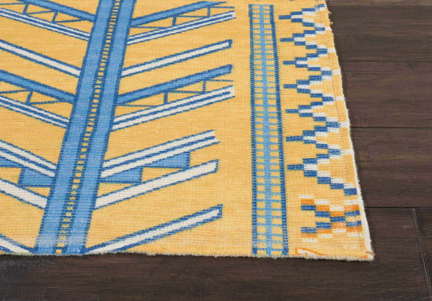 Close-up of the Nourison Madera Saffron Tribal rug. Mustard yellow with blue and white geometric patterns.
