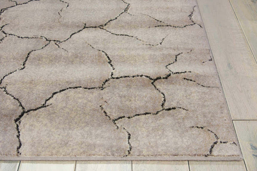 Close up of Nourison Utopia Granite rug showing gray tones and cracked earth pattern.
