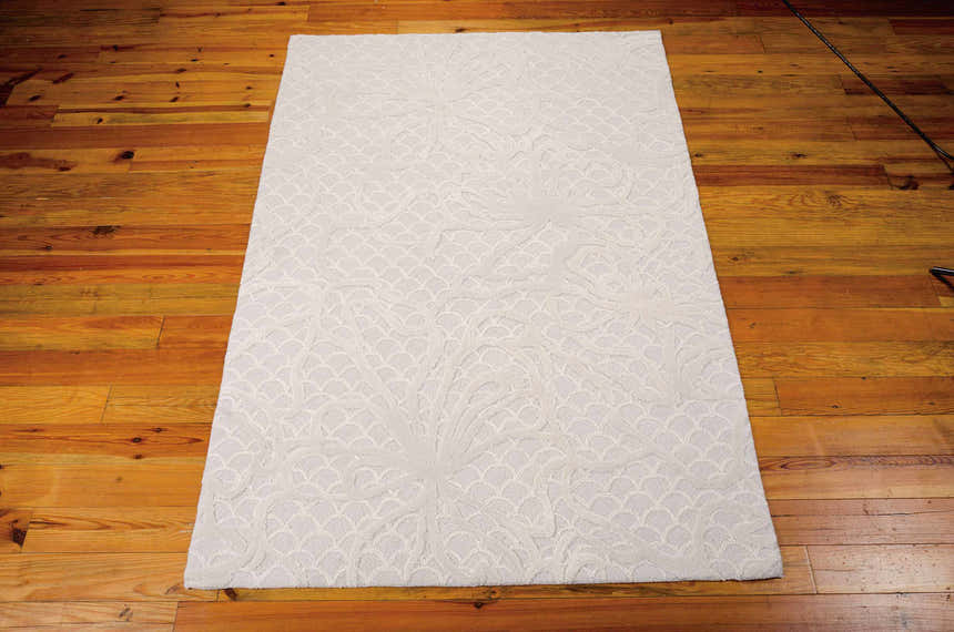 Close-up of the spa-colored Nourison Escalade Area Rug showing its floral and scalloped pattern and handmade texture.