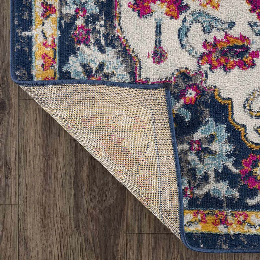 Close-up of Tigril Blue & Orange 2304 area rug showing its ivory, navy, and orange bohemian pattern and machine-made construction. Fold