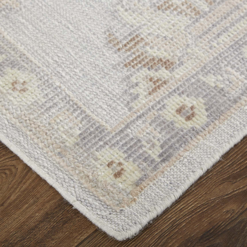 Close-up of Feizy Wendover rug corner showing ivory, silver, and tan hues, hand-knotted texture, and oriental-inspired design. Corner