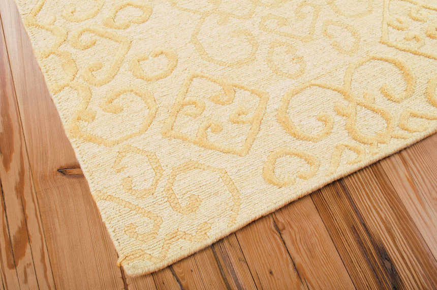 Close-up of the beige Nourison Ambrose Linen rug showing wool texture and raised scroll pattern.