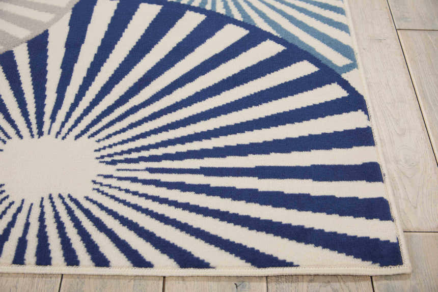 Close up of the Nourison Grafix White rug featuring a blue and white sunburst pattern.