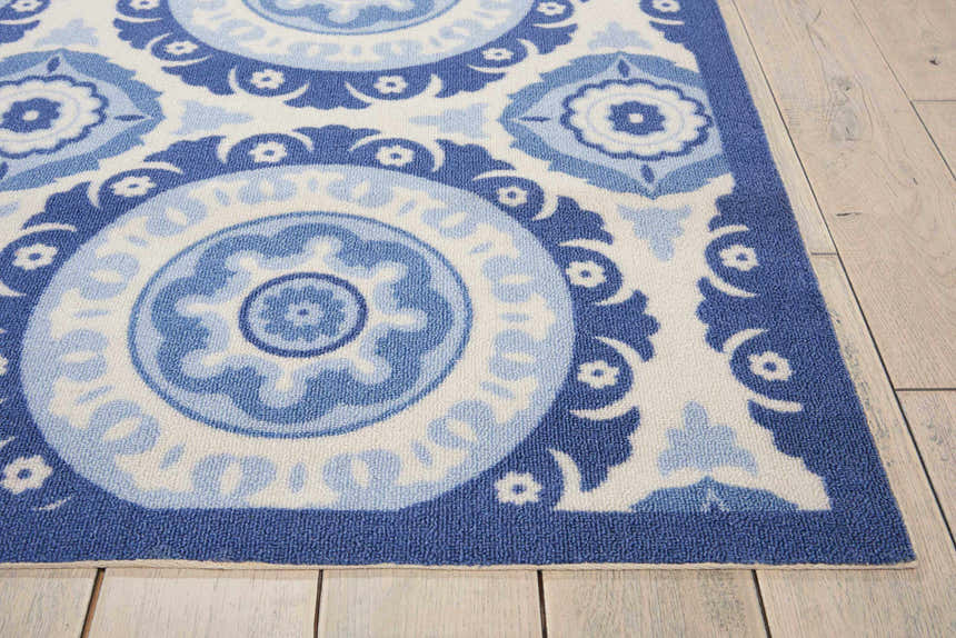 Close-up of Waverly Sun N' Shade Navy rug. Coastal style with blue and white floral medallion pattern. Machine-made texture.