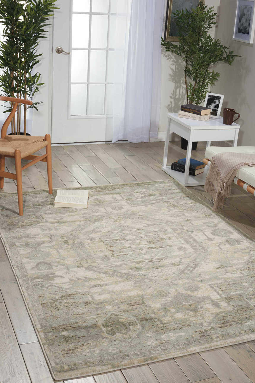 Entryway with Nourison Euphoria Ivory Persian rug, wood floors, white door, chair, and side table with decor.