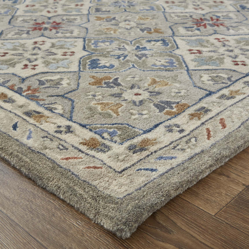 Close up of the taupe, ivory, and red Feizy Rylan area rug showing the floral and botanical pattern and wool texture. Corner