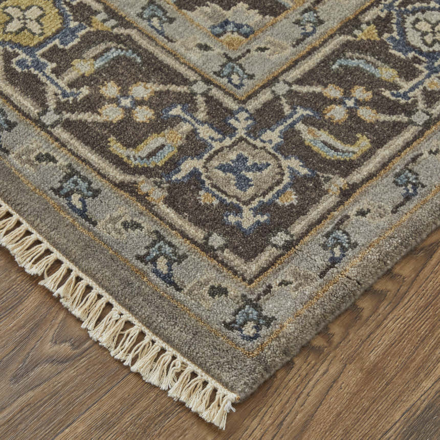 Close up of the Feizy Ustad Traditional Persian rug in gray, taupe, and blue with a detailed floral pattern and fringe. Corner