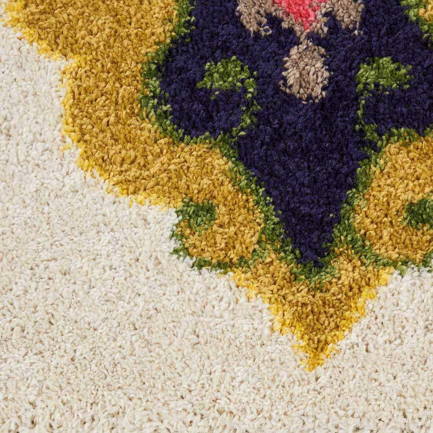 Close up of the Nourison Nomad Ivory Multicolor Floral Area Rug showing texture and floral design.