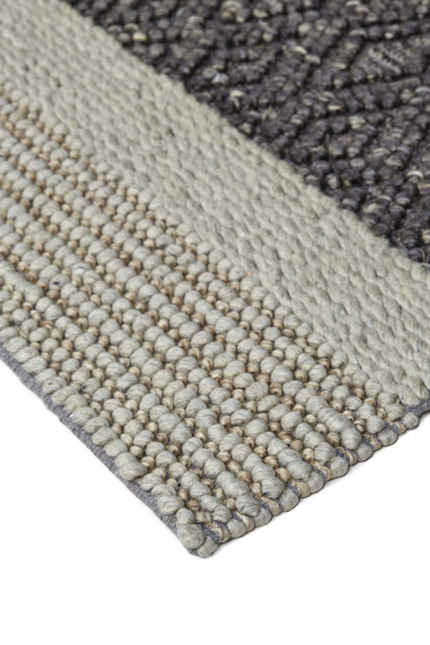 Close up of the hand woven Feizy Berkeley rug with gray, tan, and taupe stripes. Corner