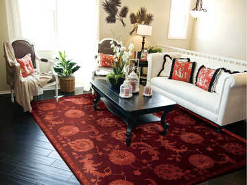 Living room with white sofa, dark wood floors, and Nourison Regal Garnet Persian Rug in dark brown and garnet.