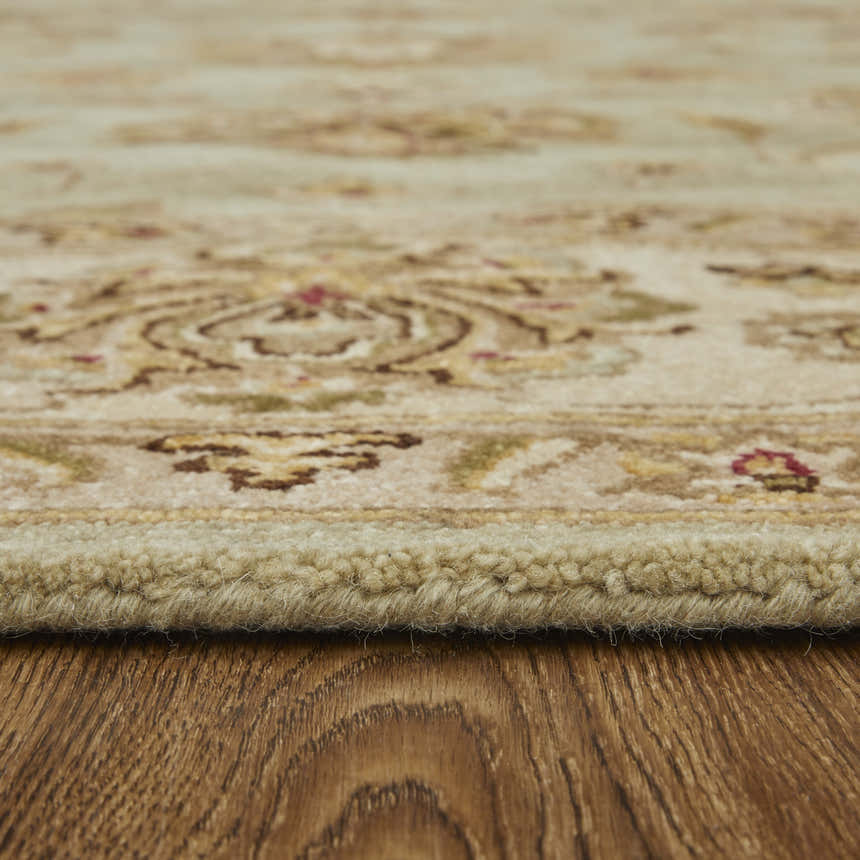 Close-up of the hand-tufted Feizy Wagner Traditional rug showing its tan, brown, and green floral design and wool texture. Pile
