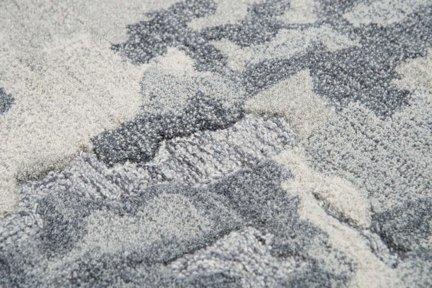 Close-up of the hand-tufted Rizzy VOG109 area rug. Gray and medium gray wool with a contemporary abstract pattern. Texture