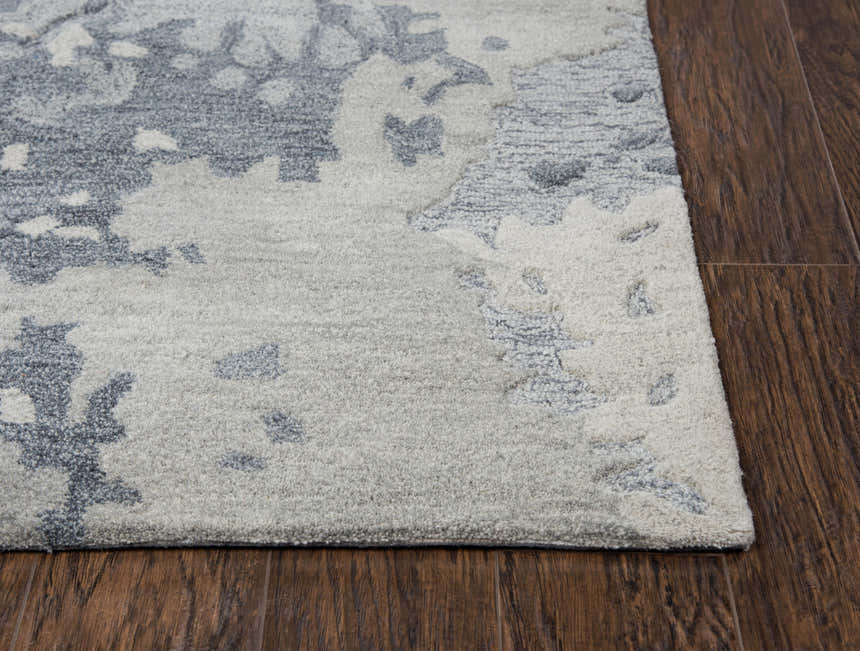 Close-up of the hand-tufted Rizzy VOG109 area rug. Gray and medium gray wool with a contemporary abstract pattern. Corner