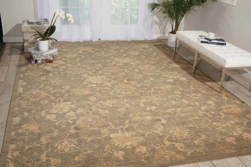 Living room scene with olive Nourison Silken Allure rug, white bench, wood floors, and natural light. Vintage style.