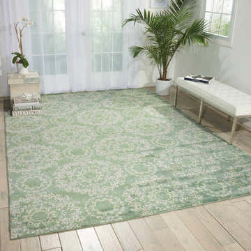 Light green living room with a Nourison Tranquility Bohemian area rug and white bench.