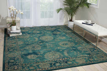 Bright living room with a Nourison 2020 Teal Traditional Indoor Area Rug, white bench, orchids, and natural light.