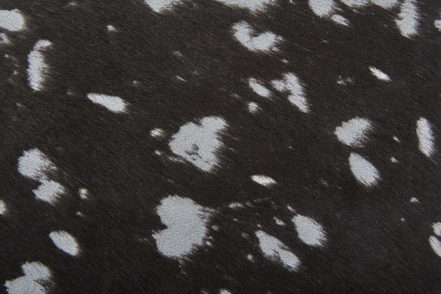 Close-up of the Feizy Ellyse Rug, a silver and brown animal print with a soft, textured cowhide feel. Texture