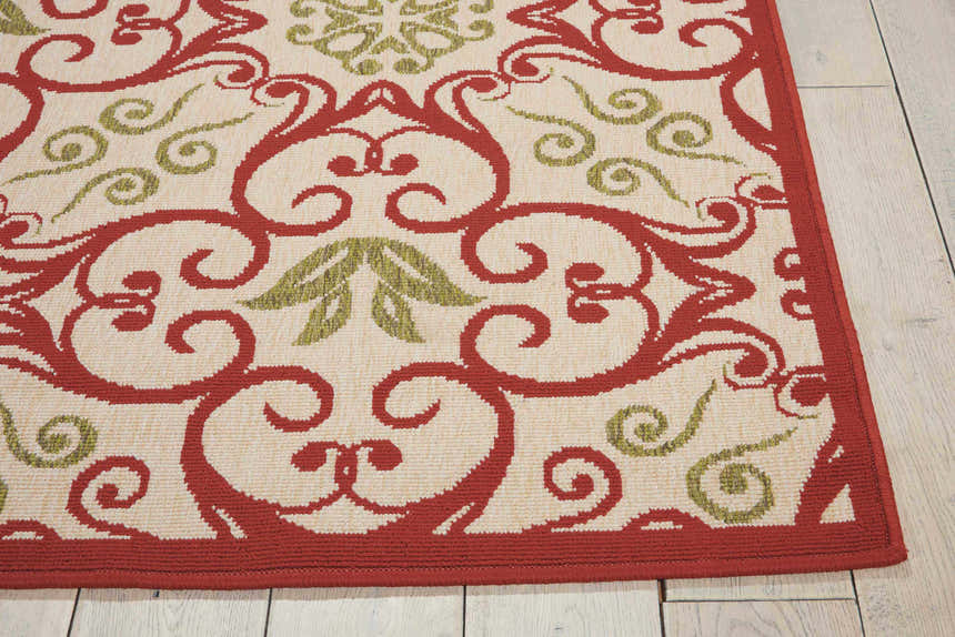 Close up of Nourison Caribbean Ivory Rust Area Rug showing chestnut scrolls and olive accents on a cream background.