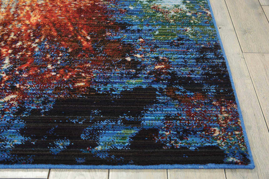 Close-up of the Nourison Chroma Red Flare rug, featuring a modern abstract design with red, blue, and black hues.