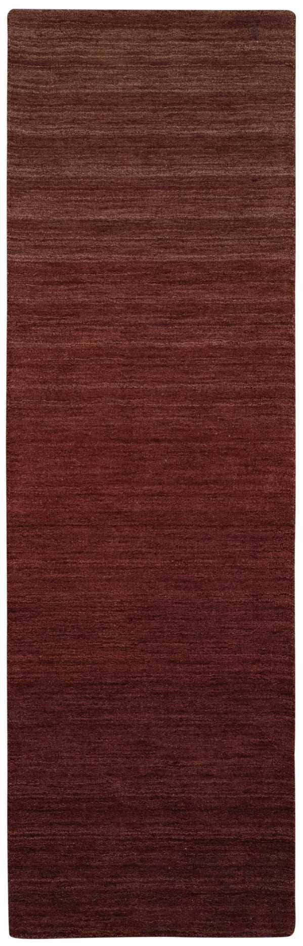 Close-up of Calvin Klein Home Haze Madder rug. Handmade wool runner rug in a rich, textured madder red color.