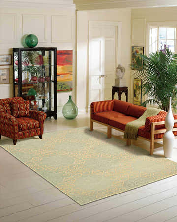Living room scene with a light green Nourison Ambrose area rug, orange furniture, and neutral walls.