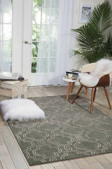 Sunlit room featuring the olive Nourison Vita Moss Indoor Area Rug with an ivory geometric pattern.