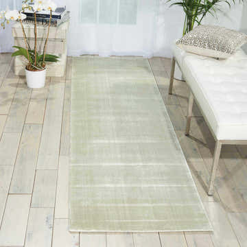 Entryway with Nourison Starlight Seafoam rug, white bench, orchids, and light wood floors. Modern, bright, and airy.