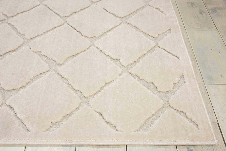 Close-up of the Michael Amini Gleam Ivory rug, showcasing its diamond pattern and soft texture on a light wood floor.
