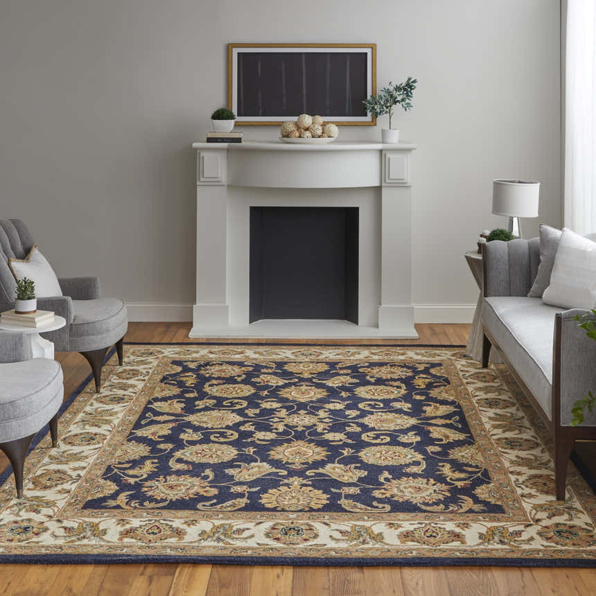Living room scene with Feizy Wagner Traditional Oriental rug in blue, tan, and gold. Fireplace, gray chairs, and hardwood floors. Roomscene-Rectangle