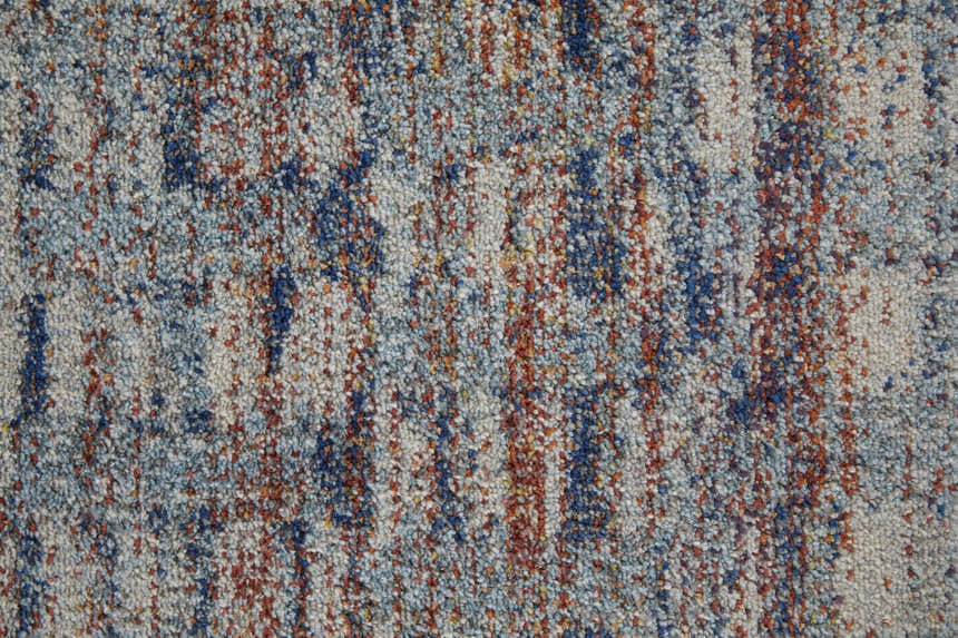 Close-up of Feizy Edgemont rug. Abstract design with blue, ivory, and orange yarns creating a textured, casual pattern. Texture